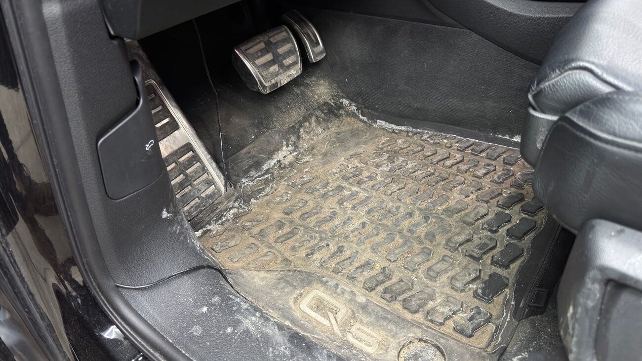 Driver floor mat buried in salt and grit